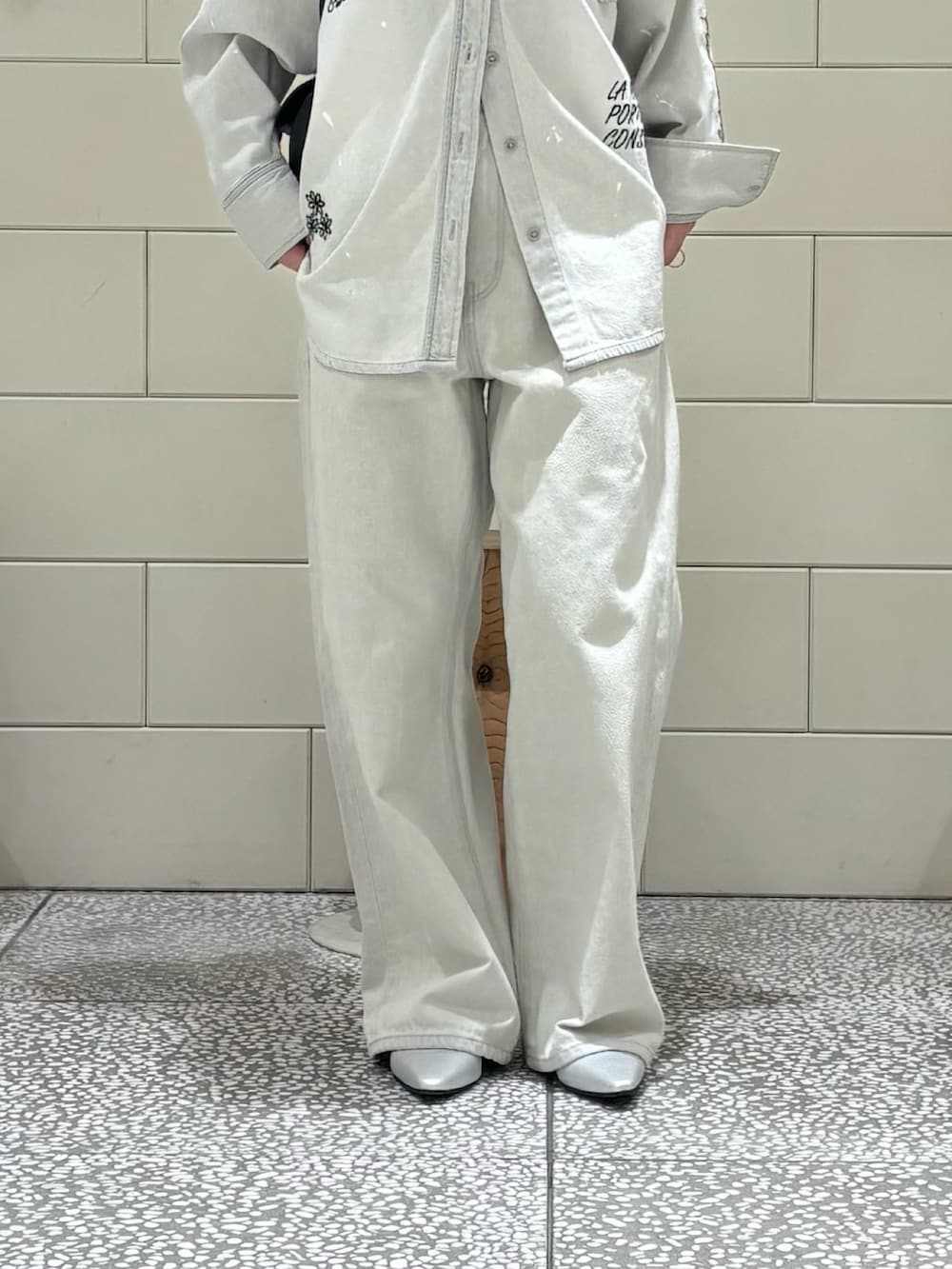 ブラック系のTシャツ/カットソー、グレー系のシャツ/ブラウス、グレー系のデニムパンツを着用したレディースの冬コーディネートの5枚目の写真