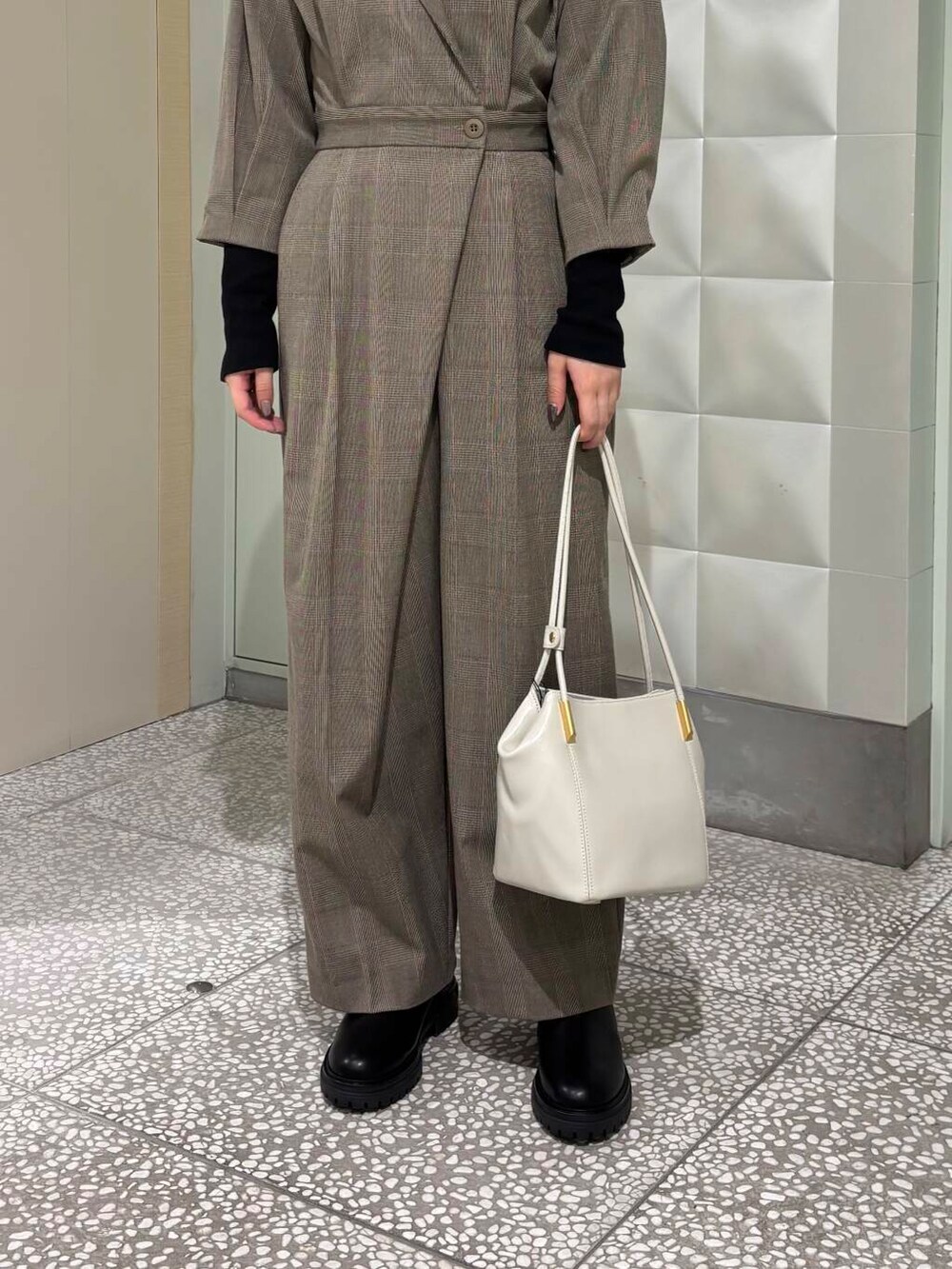 ブラック系のTシャツ/カットソー、ブラック系のブーツ、ホワイト系のトートバッグを着用したレディースの秋コーディネートの5枚目の写真