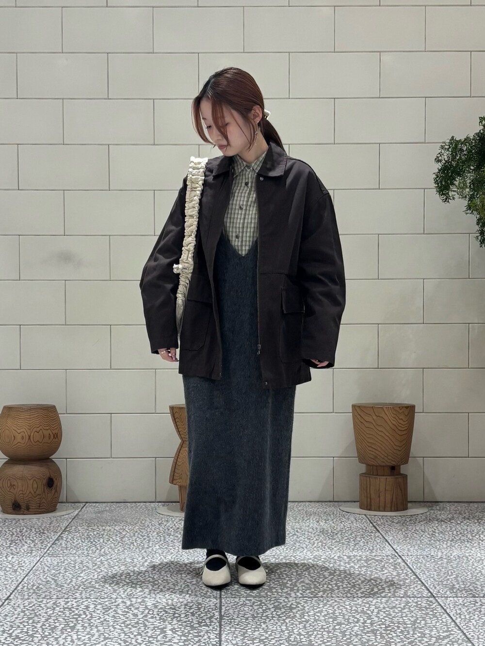 グリーン系のシャツ/ブラウス、グレー系のワンピース、ブラウン系のカバーオールを着用したレディースの冬コーディネートの2枚目の写真