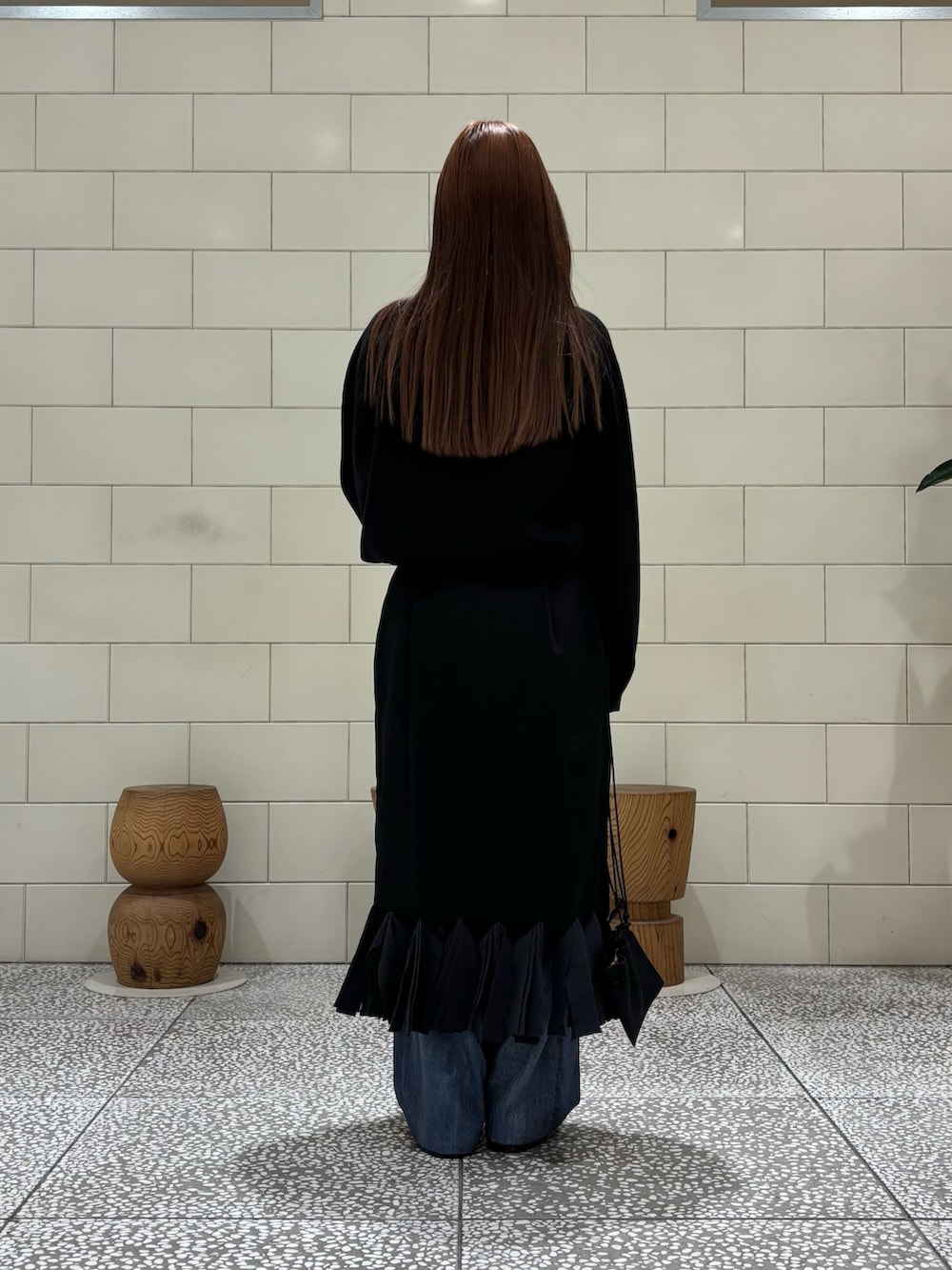 ブラック系のニット/セーター、ブルー系のその他パンツ、ブラック系のスカートを着用したレディースの秋コーディネートの3枚目の写真