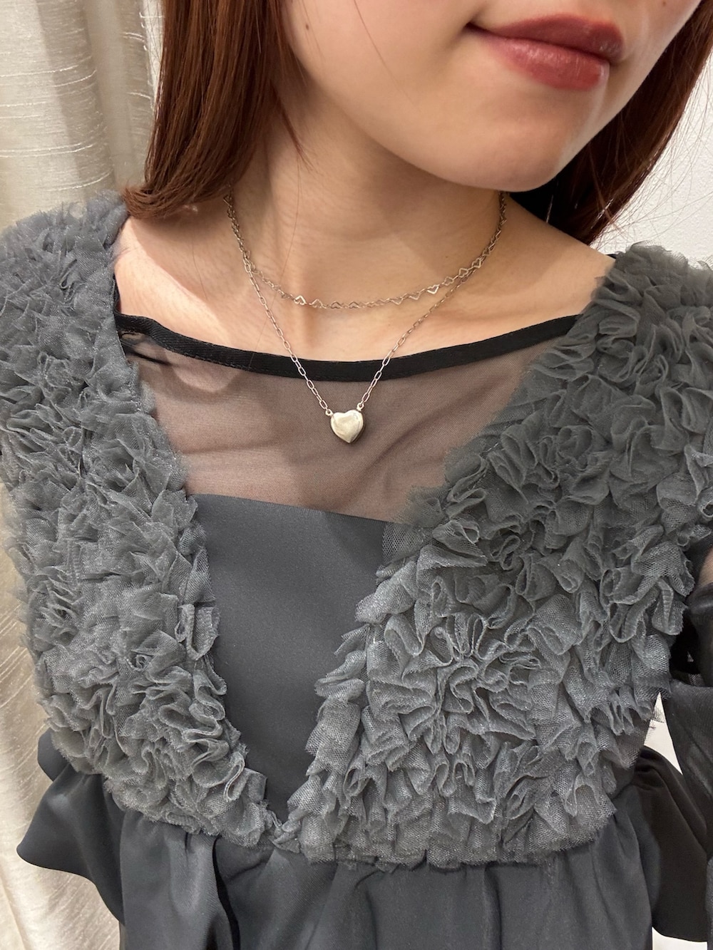 グレー系のドレス、ブラック系のテーラードジャケット、シルバー系のハンドバッグを着用したレディースの春コーディネートの5枚目の写真