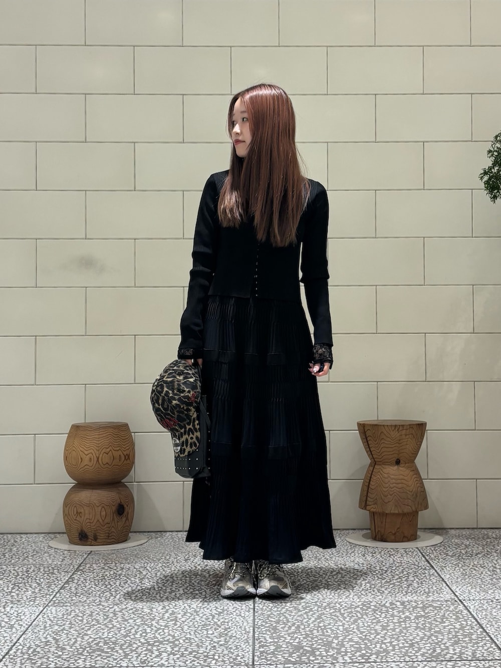 ブラック系のトートバッグ、ホワイト系のTシャツ/カットソー、ホワイト系のスニーカーを着用したレディースの春コーディネートの3枚目の写真