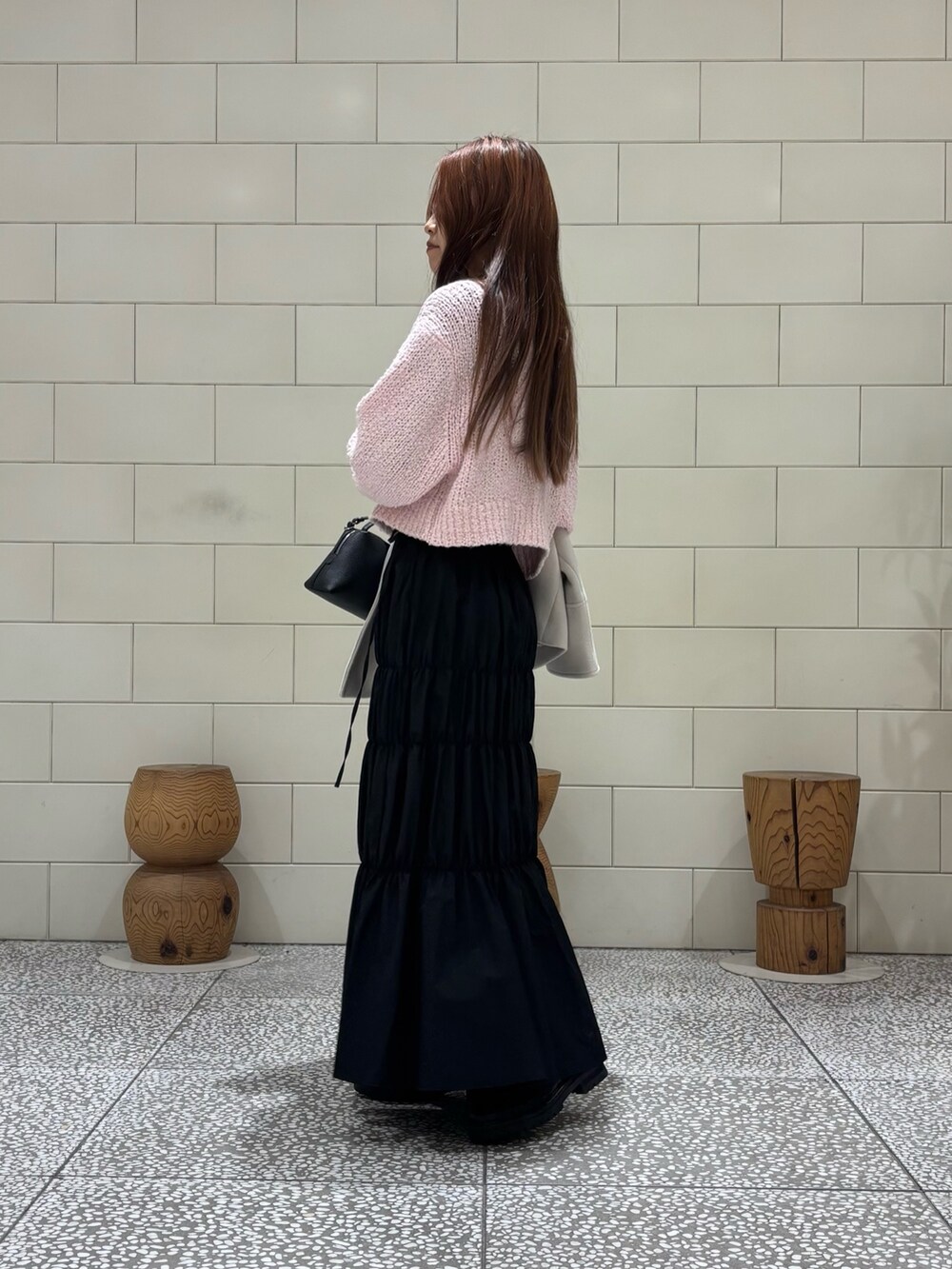 ピンク系のニット/セーター、ブラック系のスカート、ホワイト系のその他アウターを着用したレディースの冬コーディネートの4枚目の写真