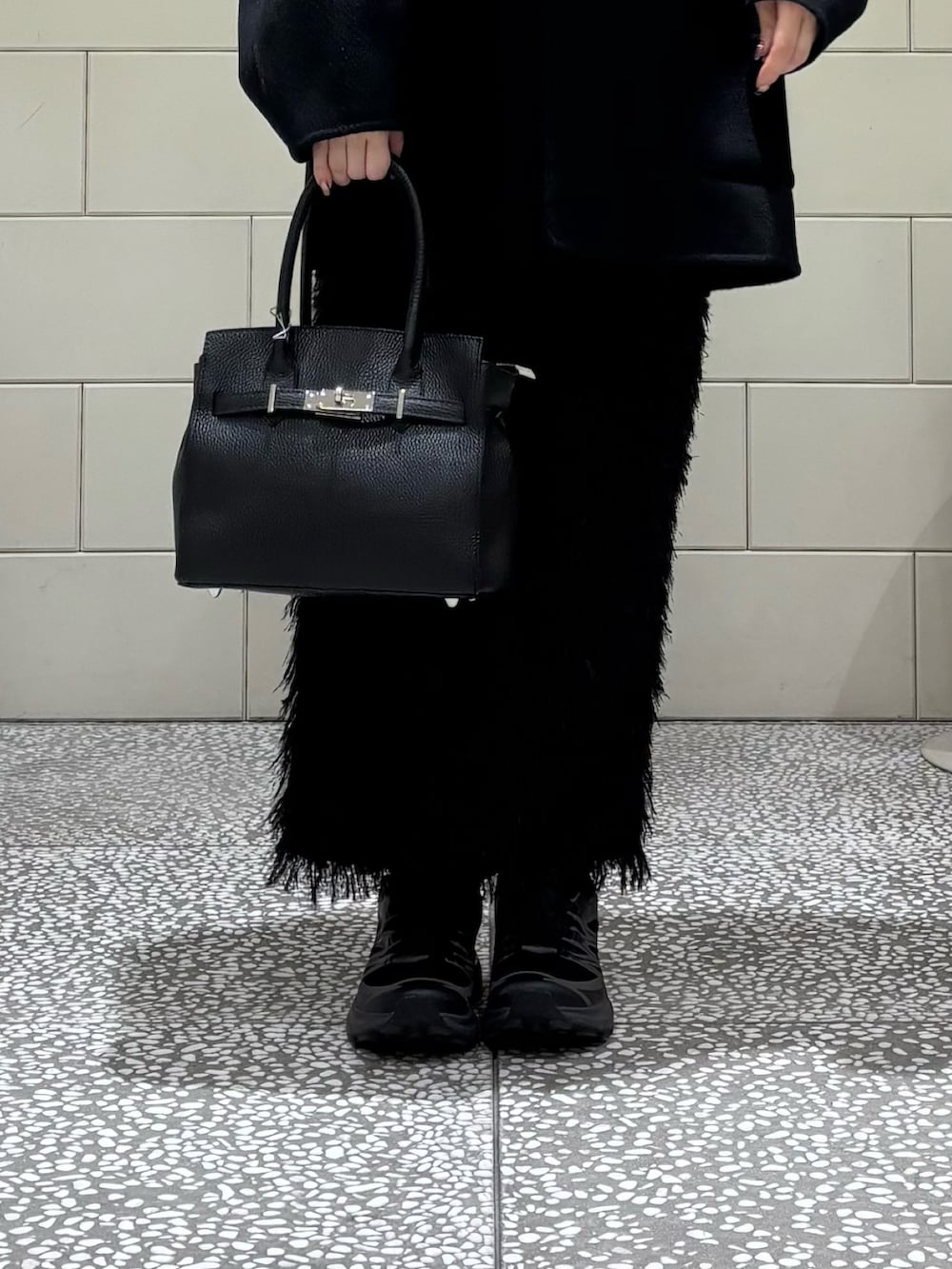 ブラック系のその他アウター、グレー系のニット/セーター、ブラック系のスカートを着用したレディースの秋コーディネートの6枚目の写真