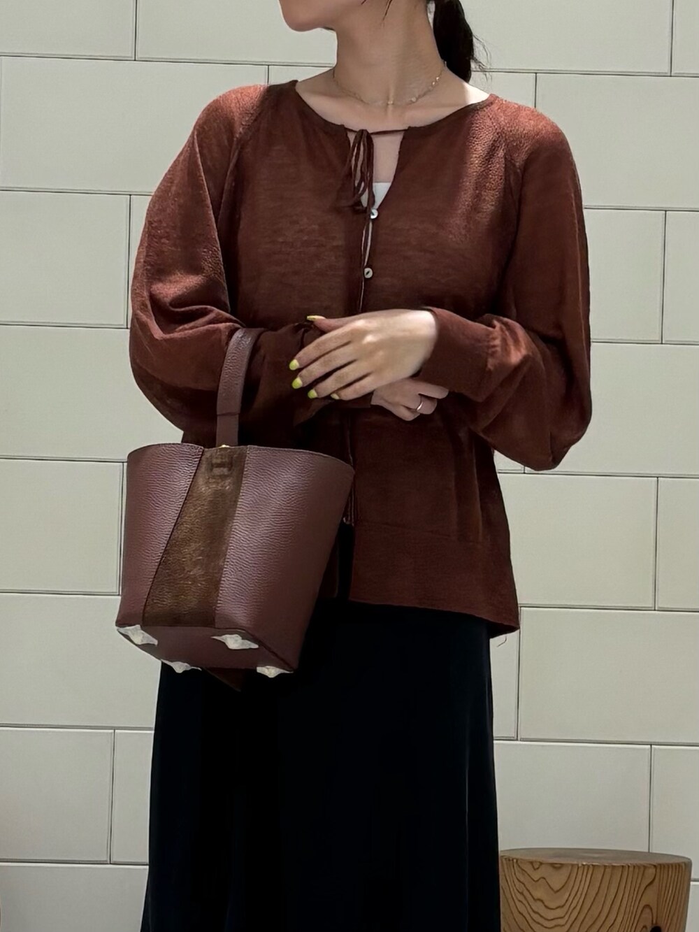 ブラック系のスカート、ブラック系のブーツ、ブラウン系のカーディガン/ボレロを着用したレディースの秋コーディネートの3枚目の写真