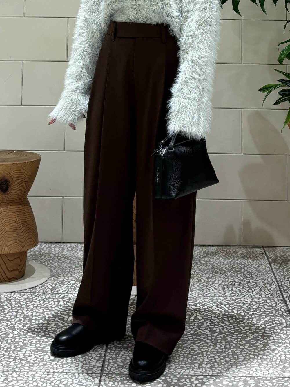 グレー系のニット/セーター、ブラック系のショルダーバッグ、ブラック系のブーツを着用したレディースの秋コーディネートの6枚目の写真