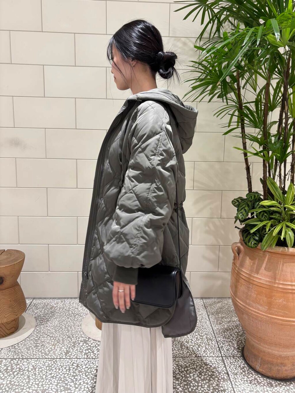 ブラウン系のニット/セーター、ホワイト系のスカート、グレー系のダウンジャケット/コートを着用したレディースの冬コーディネートの3枚目の写真