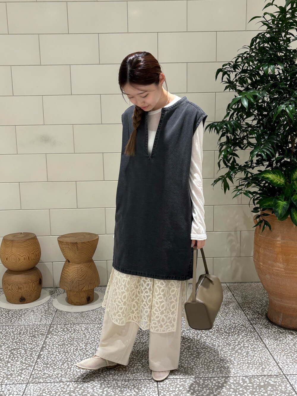 ホワイト系のTシャツ/カットソー、ブラック系のベスト、ベージュ系のハンドバッグを着用したレディースの夏コーディネートの2枚目の写真