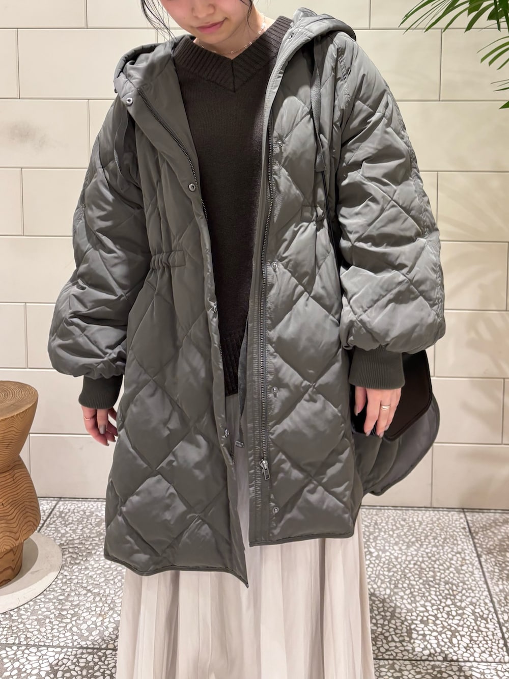 ブラウン系のニット/セーター、グレー系のダウンジャケット/コート、ブラック系のショルダーバッグを着用したレディースの冬コーディネートの2枚目の写真