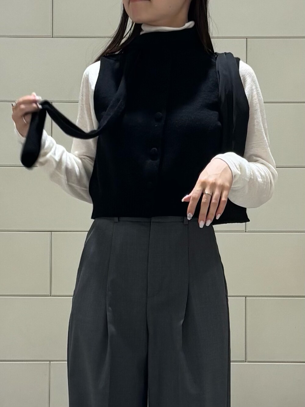 ブラック系のニット/セーター、ホワイト系のニット/セーター、グレー系のその他パンツを着用したレディースの秋コーディネートの3枚目の写真