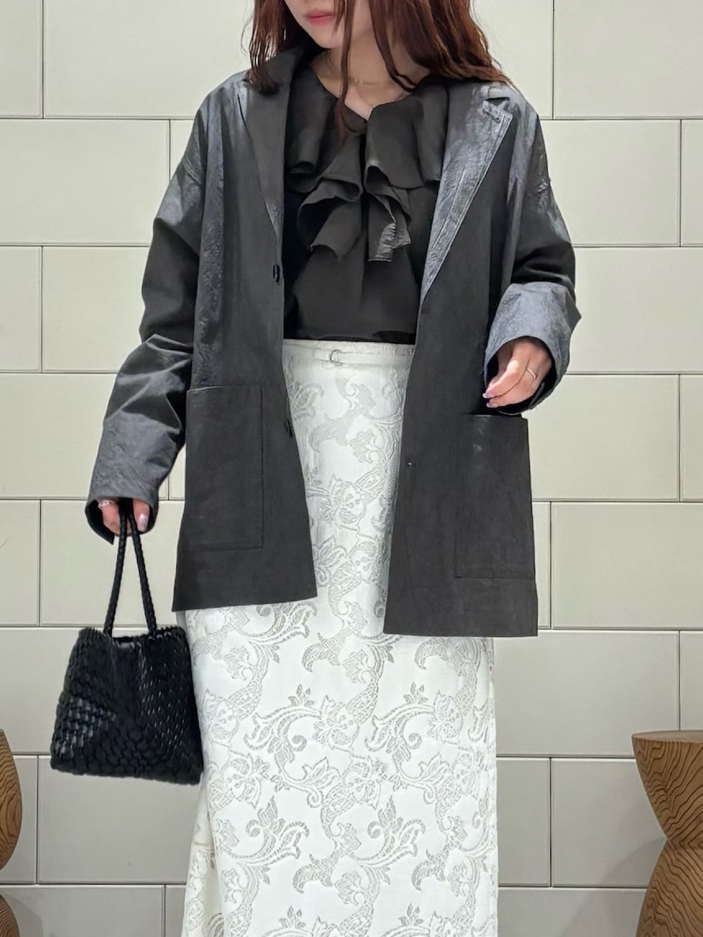 ブラウン系のシャツ/ブラウス、グレー系のその他アウター、ホワイト系のスカートを着用したレディースの春コーディネートの4枚目の写真