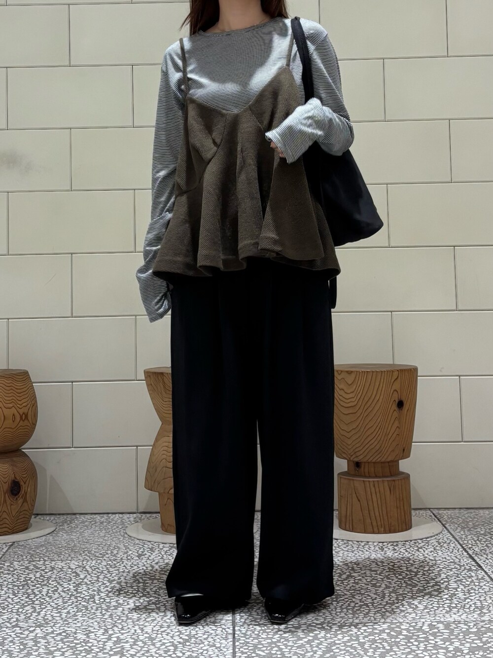 ブラック系のTシャツ/カットソー、ブラック系のその他パンツ、グリーン系のトートバッグを着用したレディースの秋コーディネートの3枚目の写真