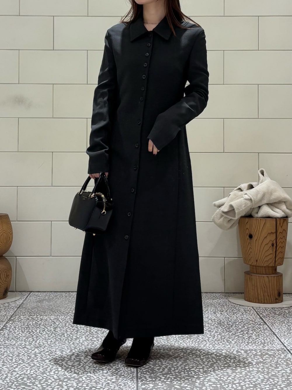 グレー系のワンピース、ホワイト系のブルゾン、ブラック系のショルダーバッグを着用したレディースの冬コーディネートの5枚目の写真