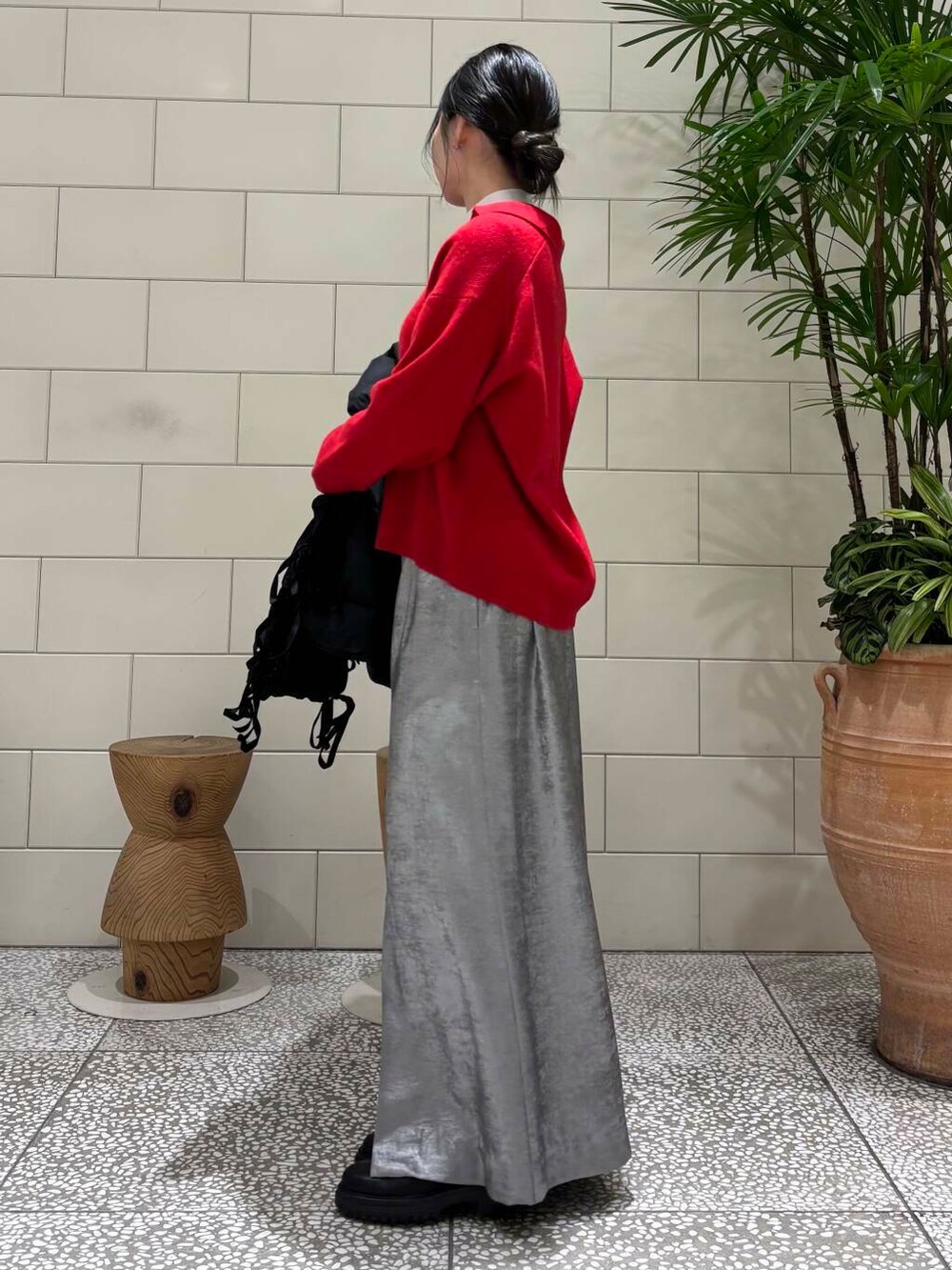 ブラック系のダウンジャケット/コート、シルバー系のスカート、レッド系のニット/セーターを着用したレディースの冬コーディネートの3枚目の写真