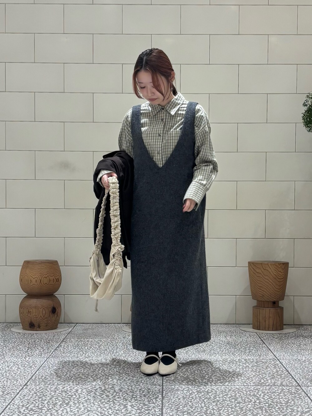 グリーン系のシャツ/ブラウス、グレー系のワンピース、ブラウン系のカバーオールを着用したレディースの冬コーディネートの4枚目の写真