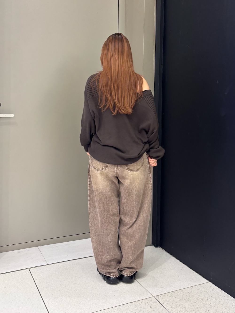 ブラウン系のニット/セーター、ブラウン系のデニムパンツを着用したレディースの秋コーディネートの2枚目の写真