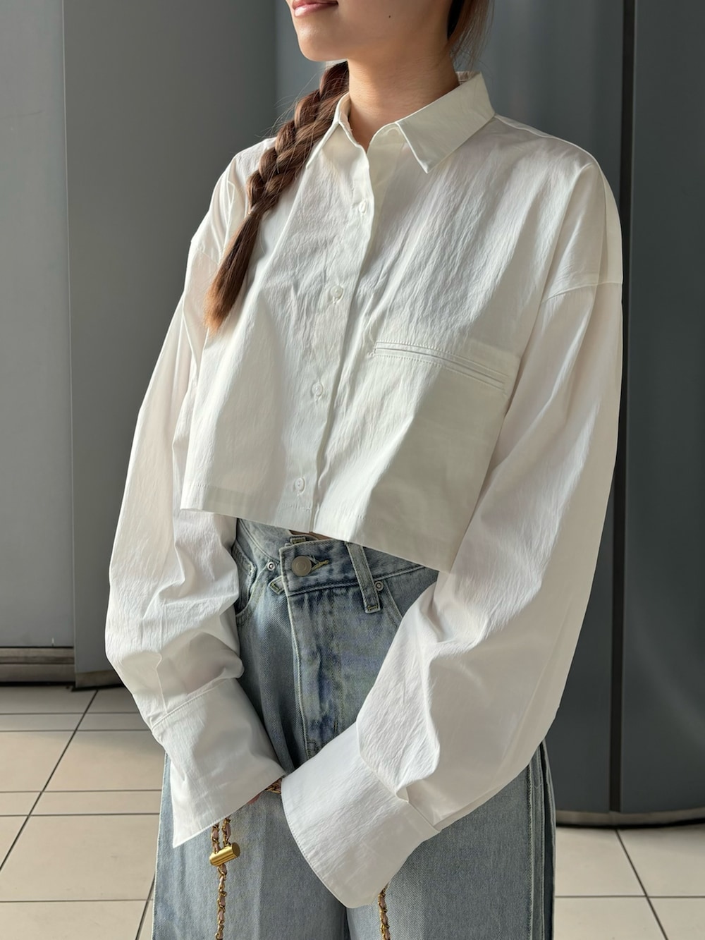 ブルー系のデニムパンツ、ホワイト系のシャツ/ブラウス、ピンク系のショルダーバッグを着用したレディースの夏コーディネートの5枚目の写真