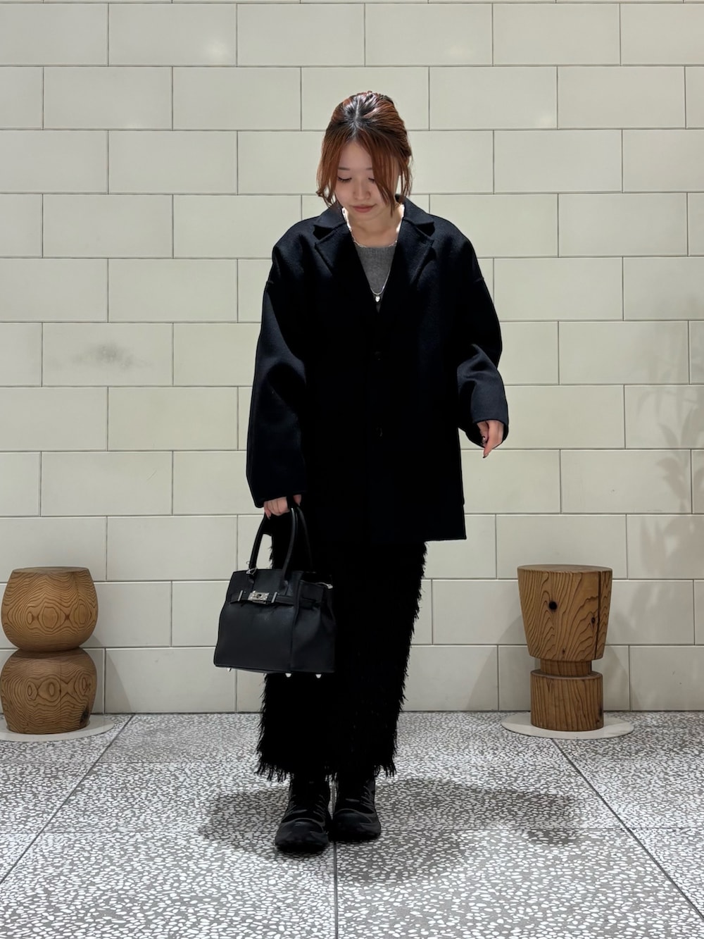 ブラック系のその他アウター、グレー系のニット/セーター、ブラック系のスカートを着用したレディースの秋コーディネートの2枚目の写真