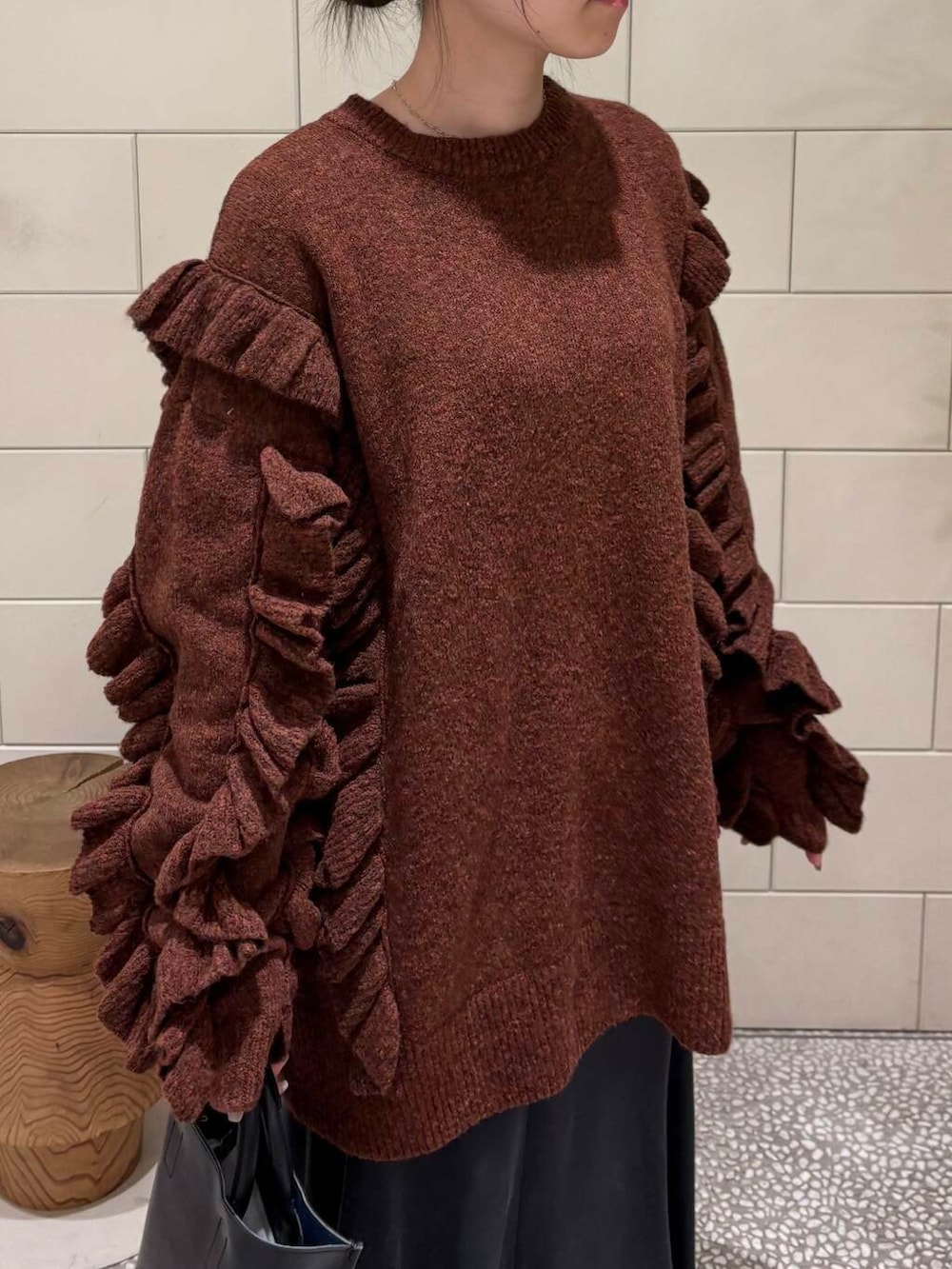 ホワイト系のスニーカー、ブラック系のトートバッグ、ブラウン系のニット/セーターを着用したレディースの冬コーディネートの3枚目の写真