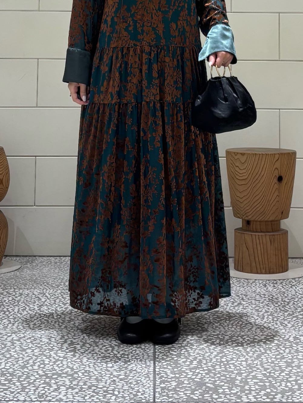 グリーン系のワンピース、ブラック系のハンドバッグ、ブラック系のバレエシューズを着用したレディースの秋コーディネートの5枚目の写真