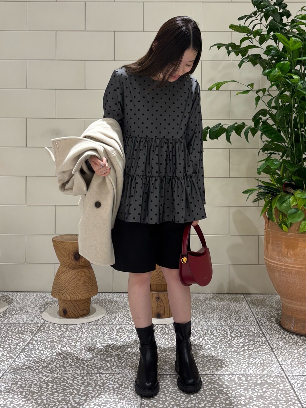 ベージュ系のピーコート、ブラック系のその他パンツ、ブラック系のブーツを着用したレディースの秋コーディネートの3枚目の写真