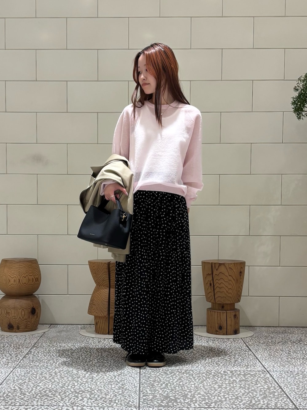 ホワイト系のタンクトップ、ピンク系のニット/セーター、ブラック系のスカートを着用したレディースの冬コーディネートの3枚目の写真