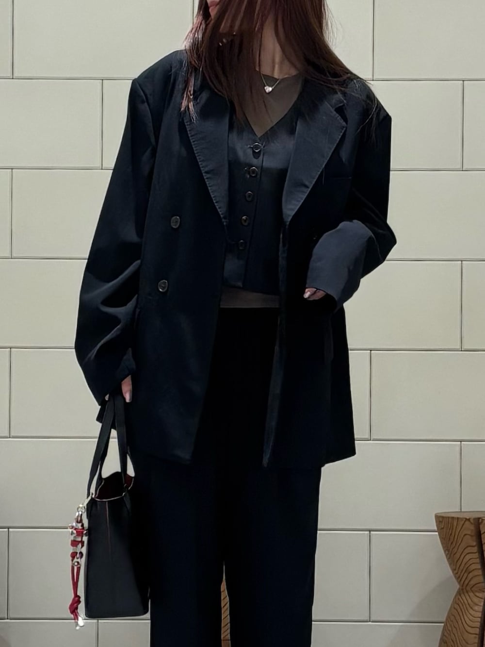 ブラック系のその他アウター、ブラック系のその他パンツ、ブラック系のハンドバッグを着用したレディースの春コーディネートの5枚目の写真