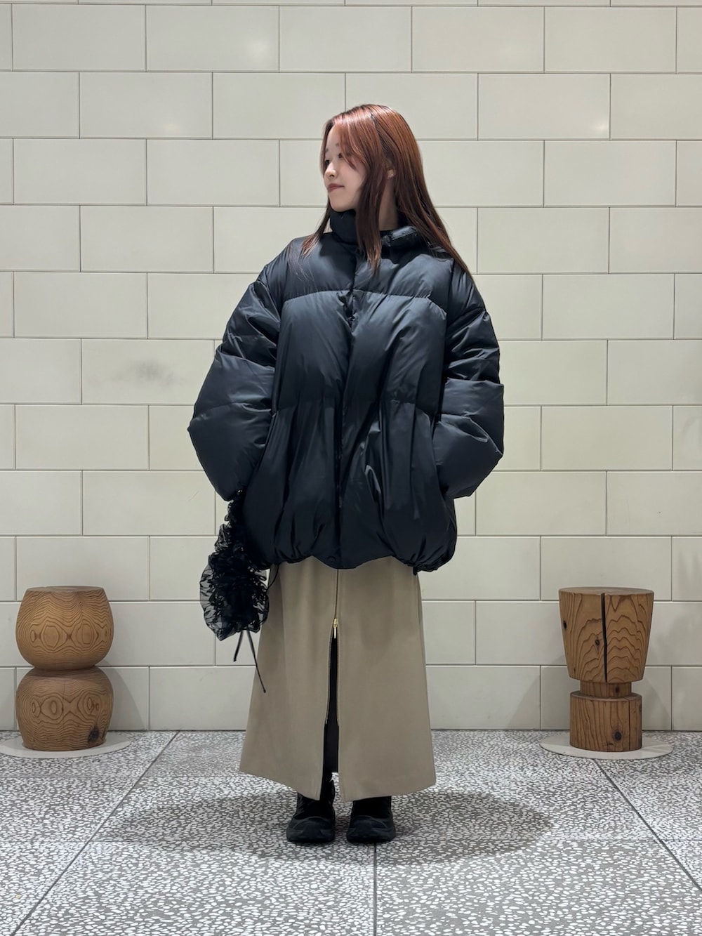 ブラック系のダウンジャケット/コート、ブラック系のニット/セーター、ベージュ系のスカートを着用したレディースの冬コーディネートの3枚目の写真