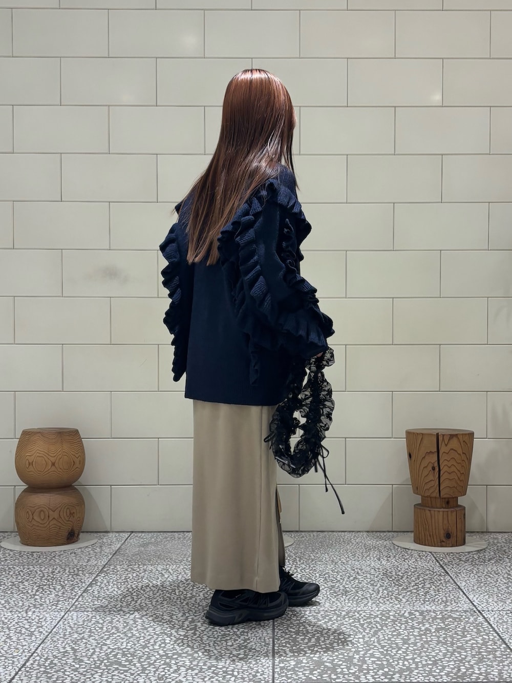 ブラック系のダウンジャケット/コート、ブラック系のニット/セーター、ベージュ系のスカートを着用したレディースの冬コーディネートの5枚目の写真