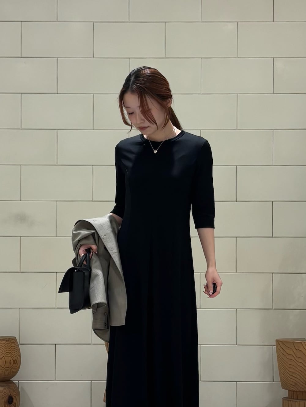 ブラック系のワンピース、ベージュ系のシャツ/ブラウス、ブラック系のハンドバッグを着用したレディースの冬コーディネートの6枚目の写真