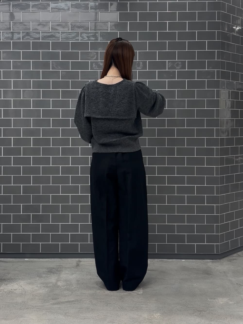 グレー系のニット/セーター、ブラック系のその他パンツ、ブラック系のスニーカーを着用したレディースの秋コーディネートの3枚目の写真