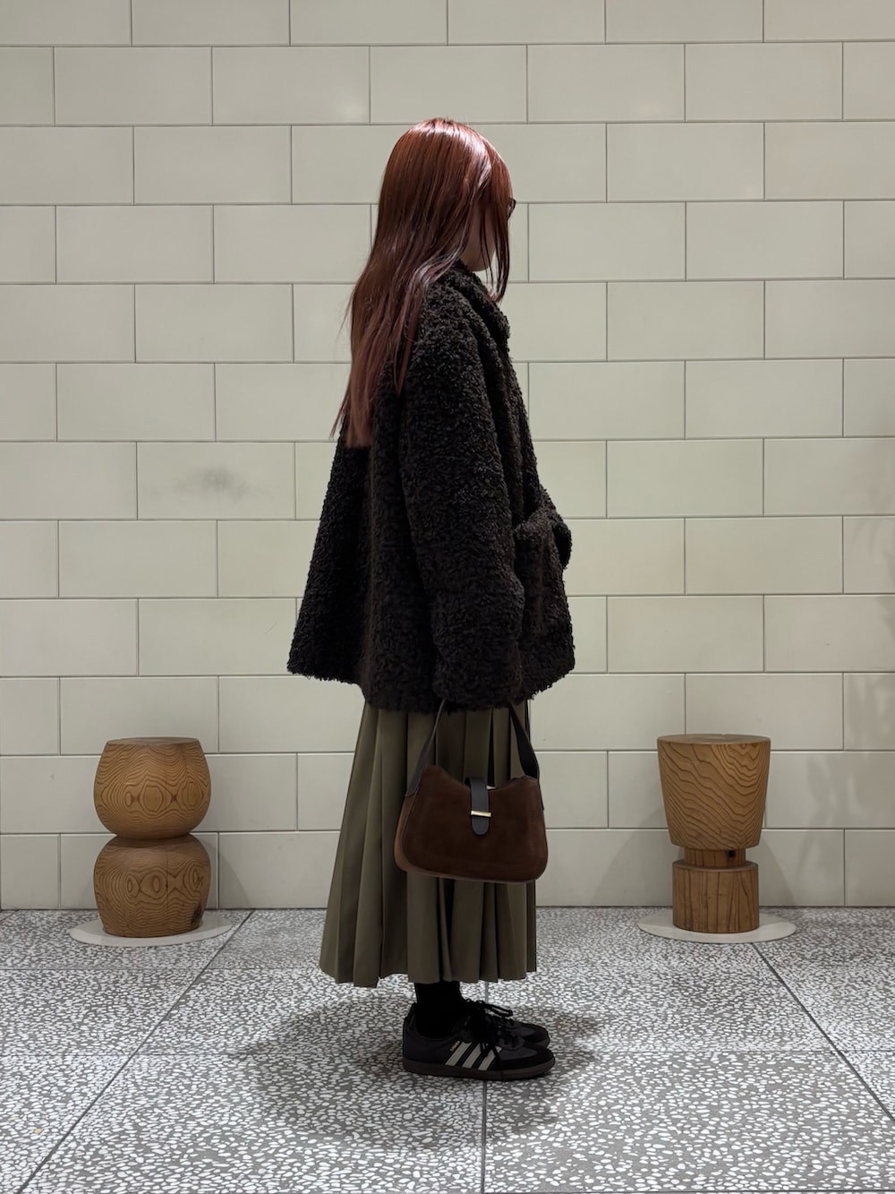 ブラウン系のスニーカー、グリーン系のスカート、ブラウン系のその他アウターを着用したレディースの秋コーディネートの3枚目の写真