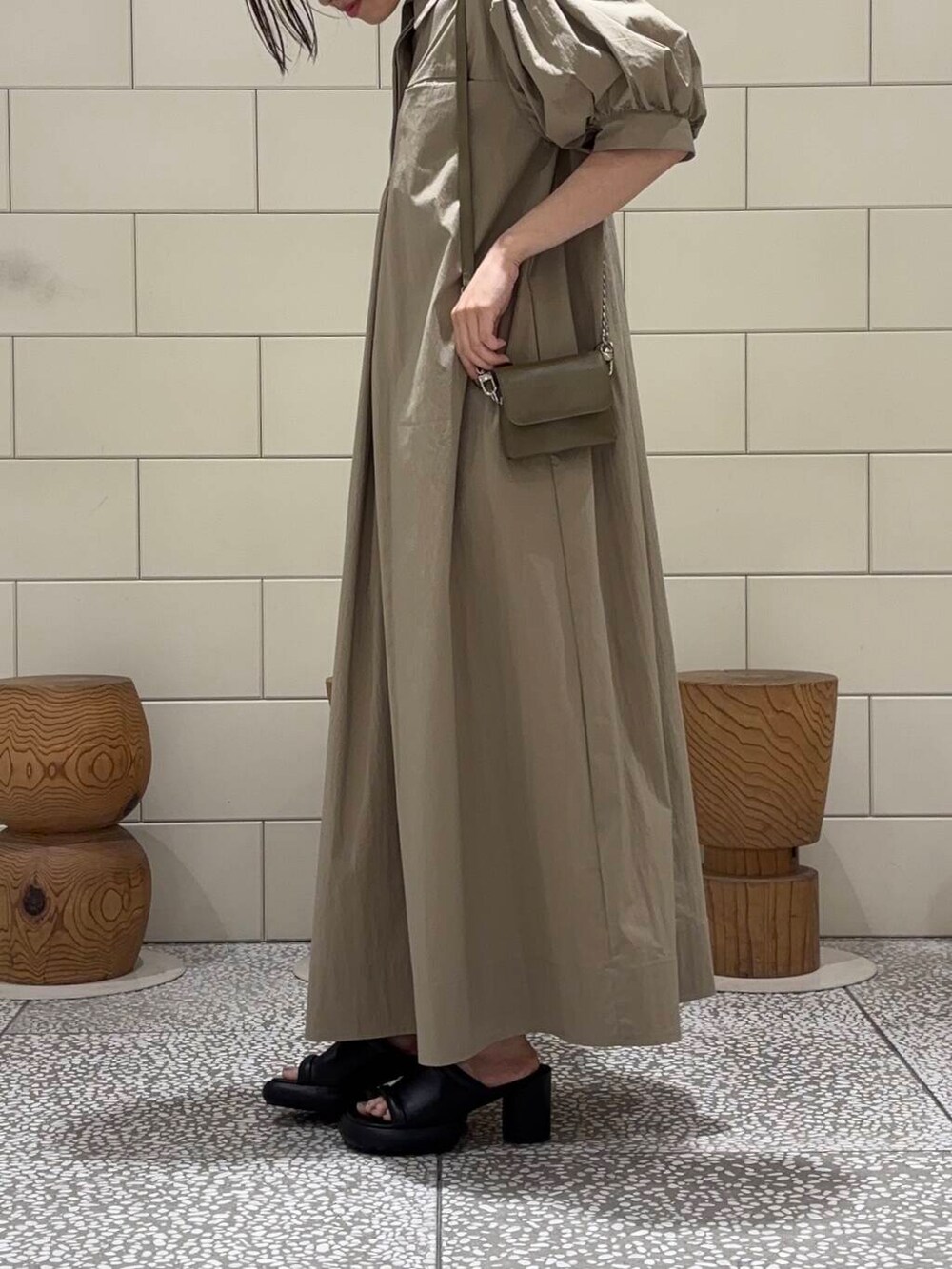 グリーン系のショルダーバッグ、ベージュ系のワンピースを着用したレディースの夏コーディネートの4枚目の写真