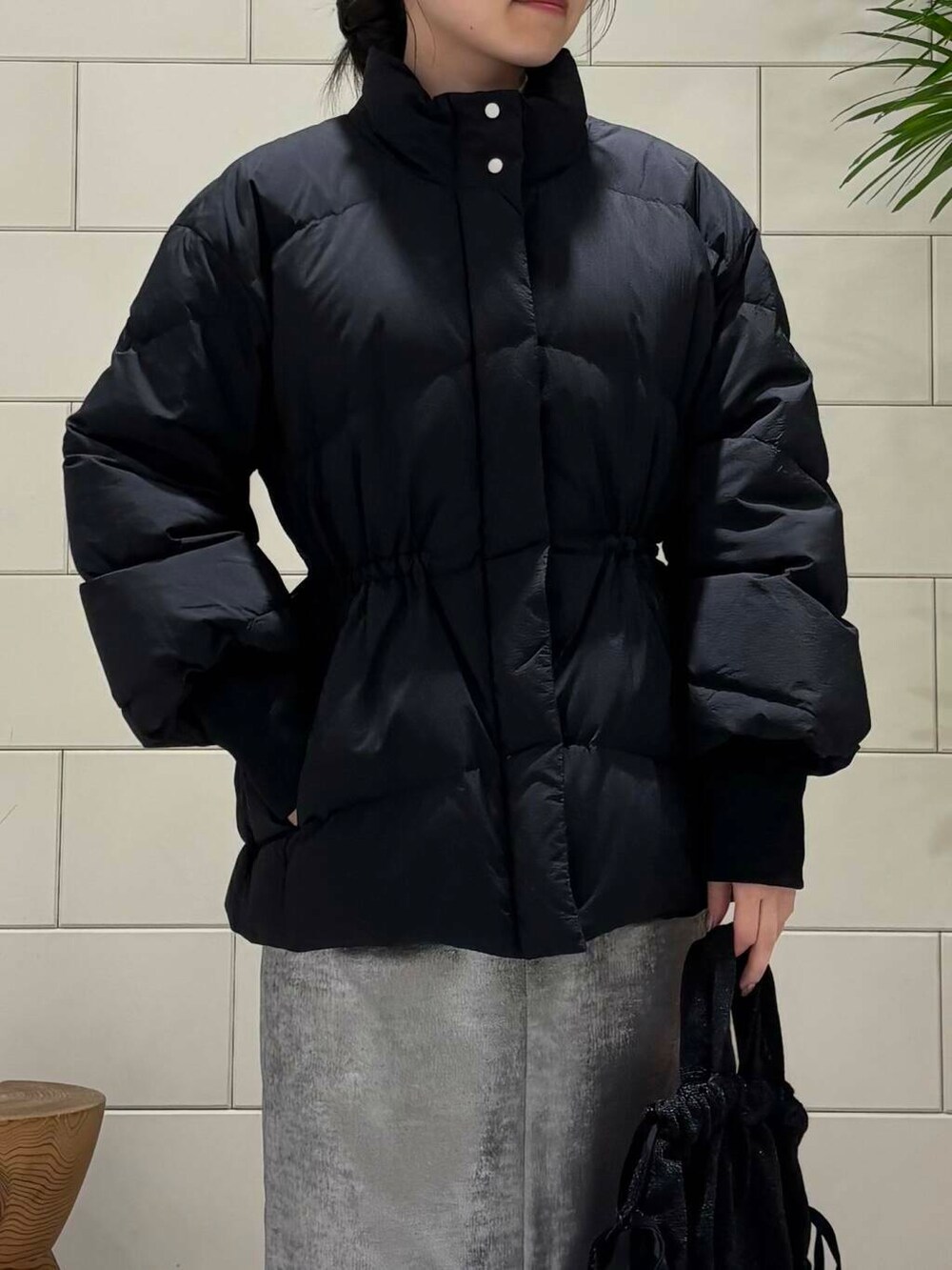 ブラック系のダウンジャケット/コート、シルバー系のスカート、レッド系のニット/セーターを着用したレディースの冬コーディネートの5枚目の写真