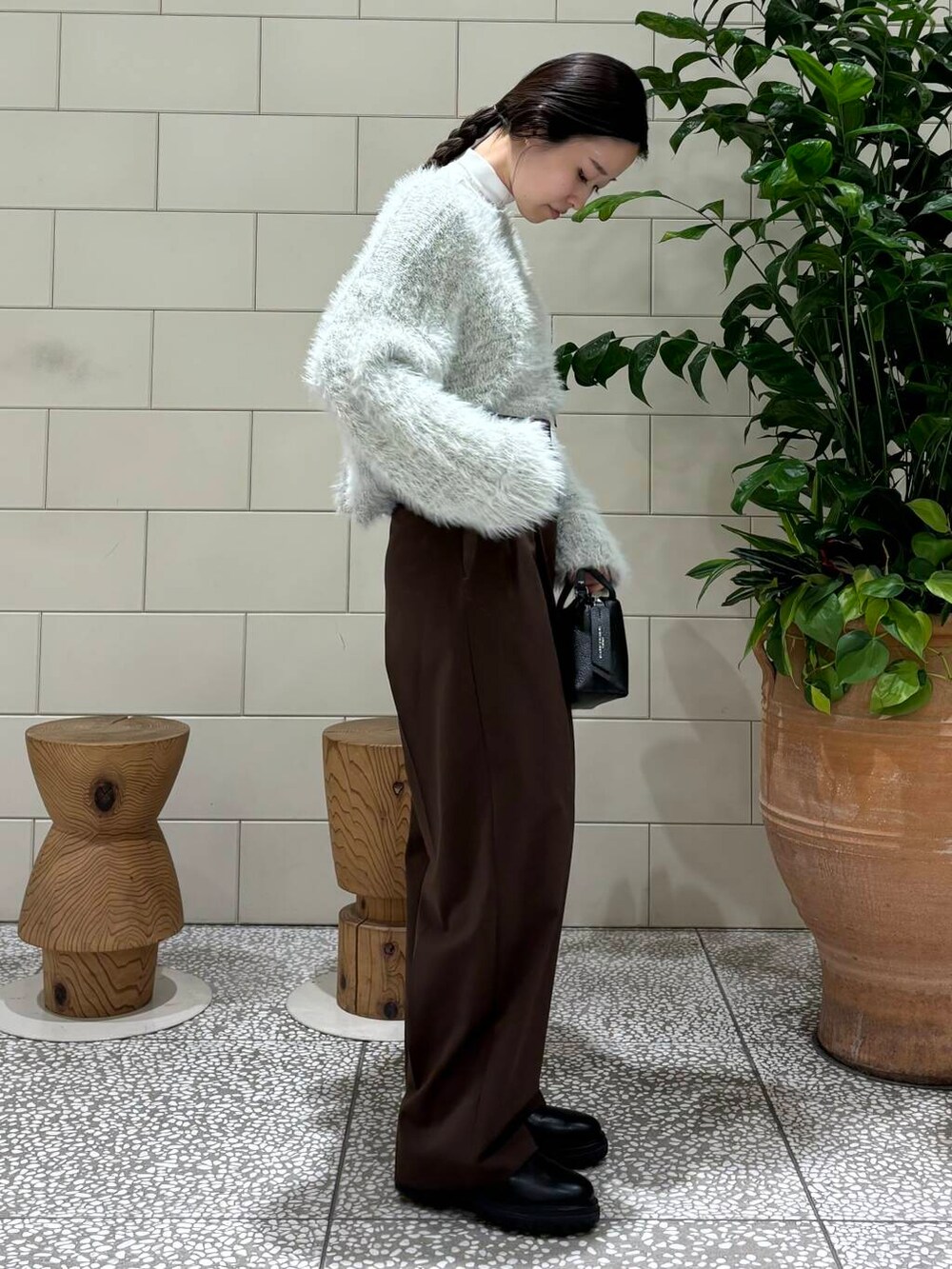 ブラウン系のその他パンツ、グレー系のニット/セーター、ブラック系のハンドバッグを着用したレディースの秋コーディネートの2枚目の写真