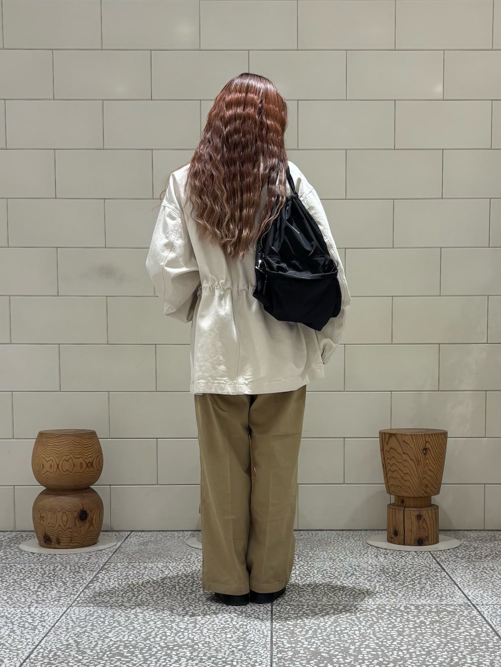 ベージュ系のその他パンツ、ベージュ系のカバーオール、ブラウン系のバックパック/リュックを着用したレディースの冬コーディネートの4枚目の写真