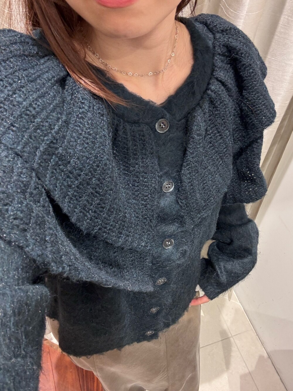 ブラウン系のスカート、ブラック系のブーツ、グリーン系のニット/セーターを着用したレディースの秋コーディネートの5枚目の写真