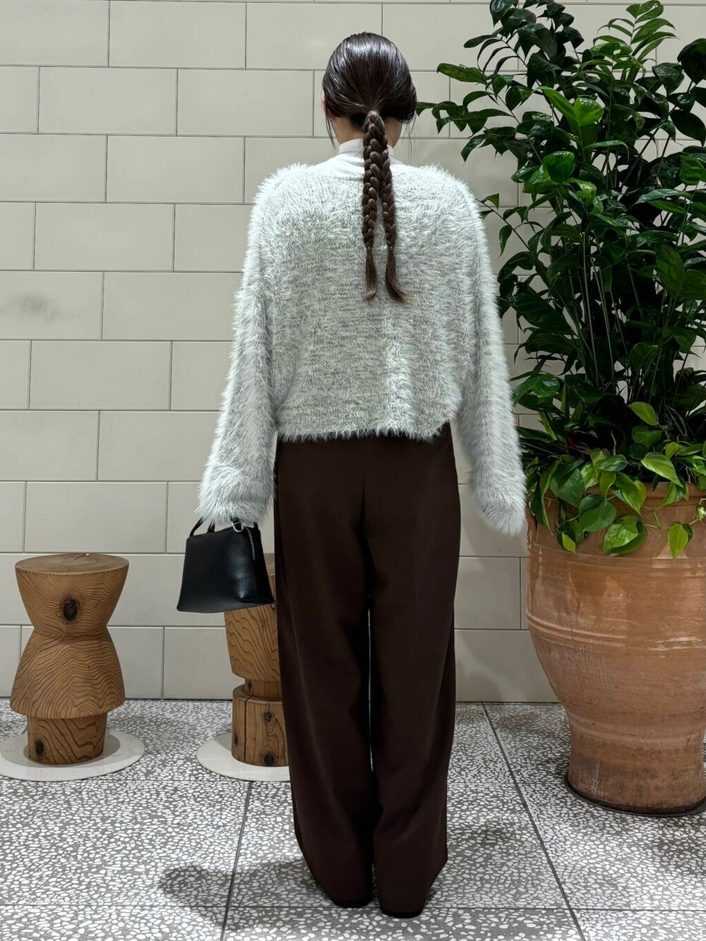 ブラウン系のその他パンツ、グレー系のニット/セーター、ブラック系のハンドバッグを着用したレディースの秋コーディネートの4枚目の写真