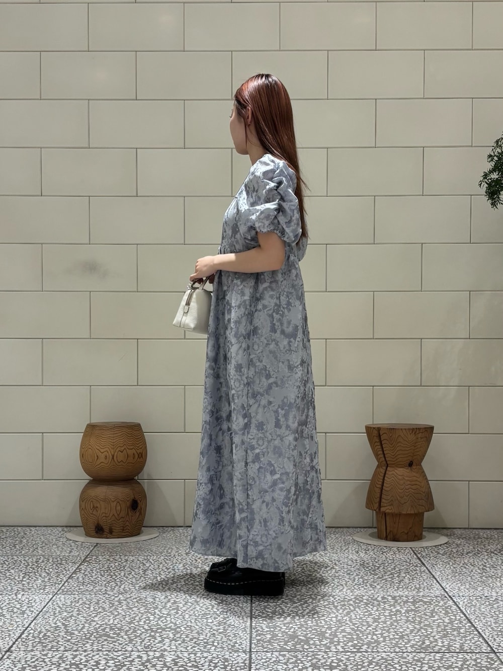 グレー系のドレス、ホワイト系のショルダーバッグを着用したレディースの春コーディネートの2枚目の写真