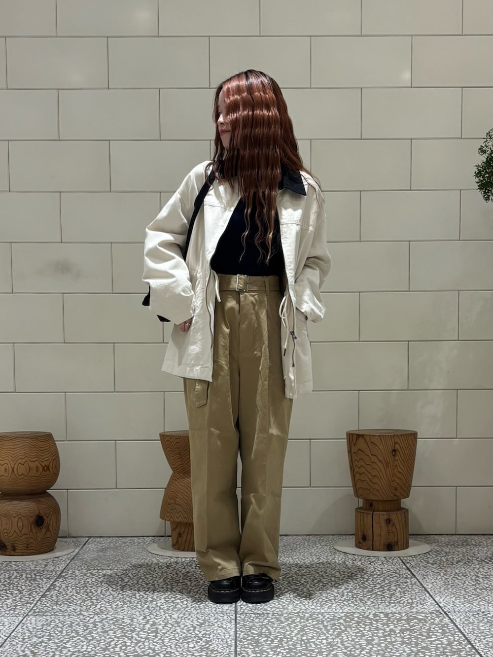 ベージュ系のその他パンツ、ベージュ系のカバーオール、ブラウン系のバックパック/リュックを着用したレディースの冬コーディネートの3枚目の写真