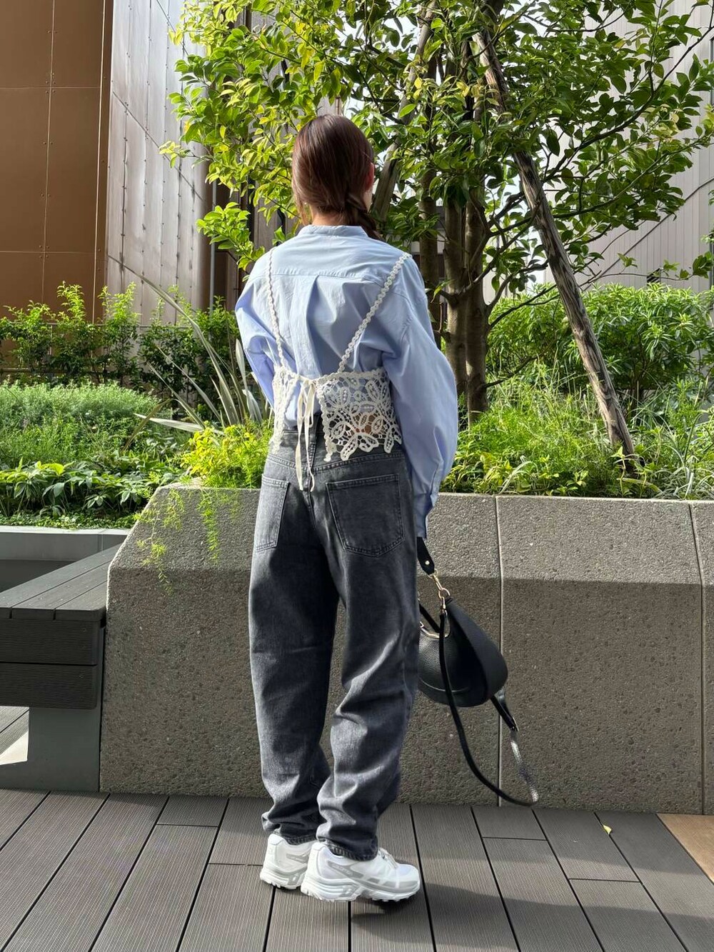 グレー系のデニムパンツ、ホワイト系のスニーカー、ブラック系のショルダーバッグを着用したレディースの夏コーディネートの3枚目の写真