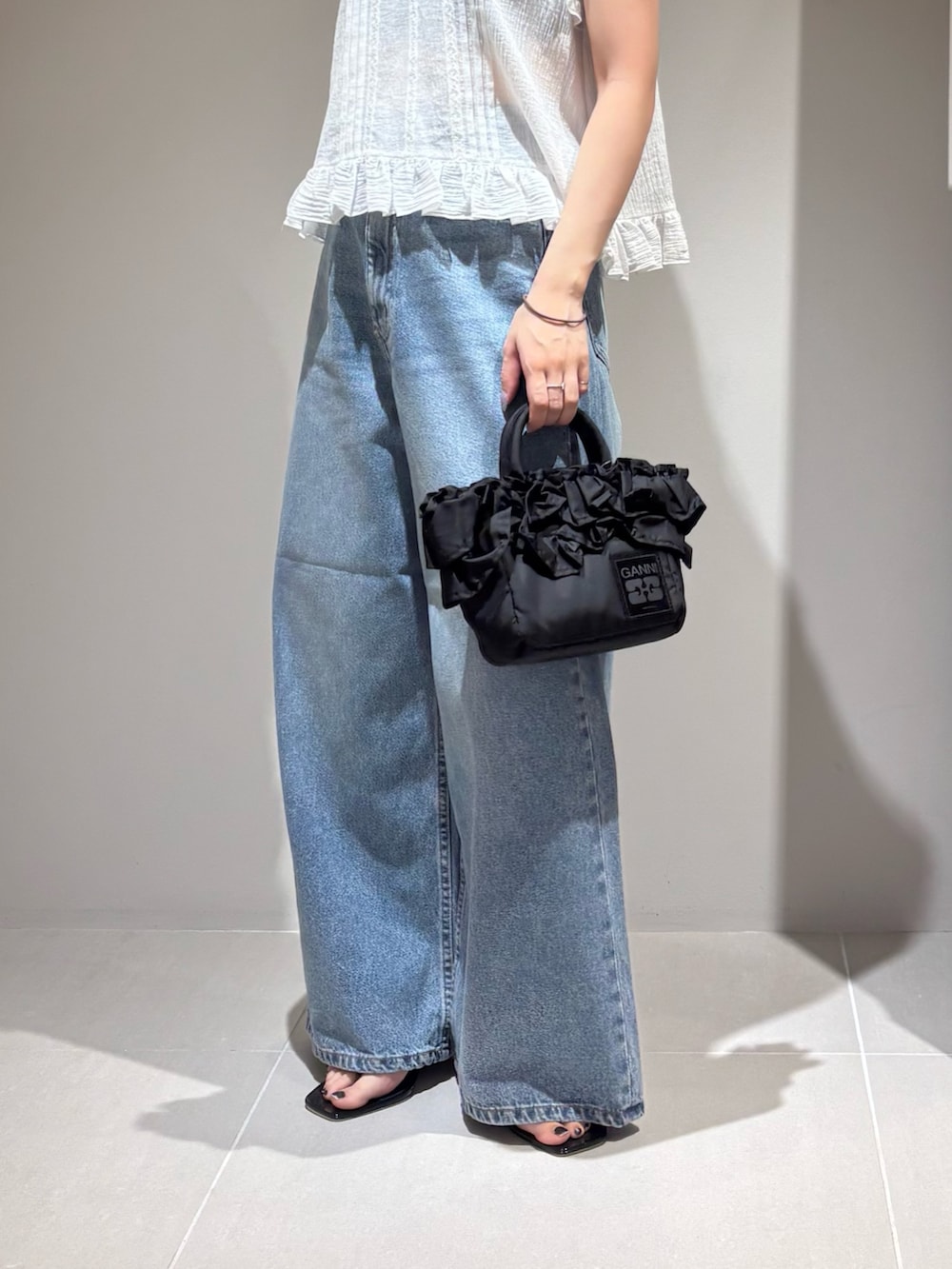 ホワイト系のシャツ/ブラウス、ブルー系のデニムパンツ、ブラック系のサンダルを着用したレディースの夏コーディネートの4枚目の写真