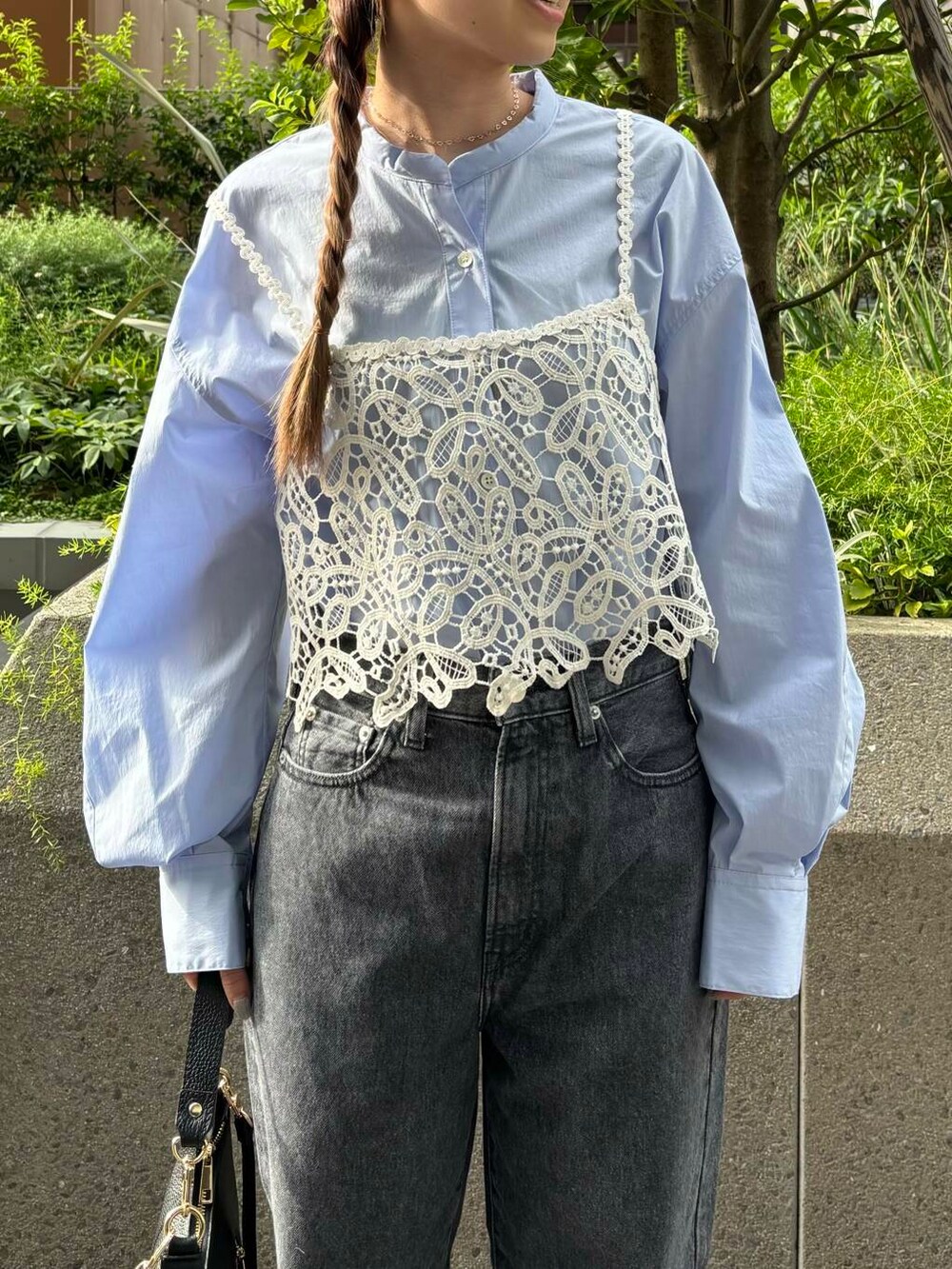 グレー系のデニムパンツ、ホワイト系のスニーカー、ブラック系のショルダーバッグを着用したレディースの夏コーディネートの5枚目の写真