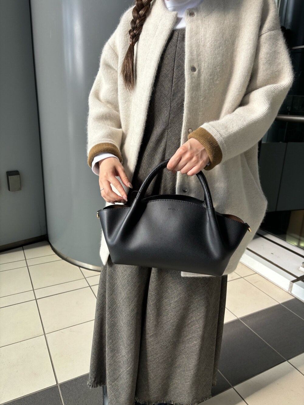 ブラウン系のワンピース、ブラック系のショルダーバッグ、ホワイト系のTシャツ/カットソーを着用したレディースの秋コーディネートの5枚目の写真