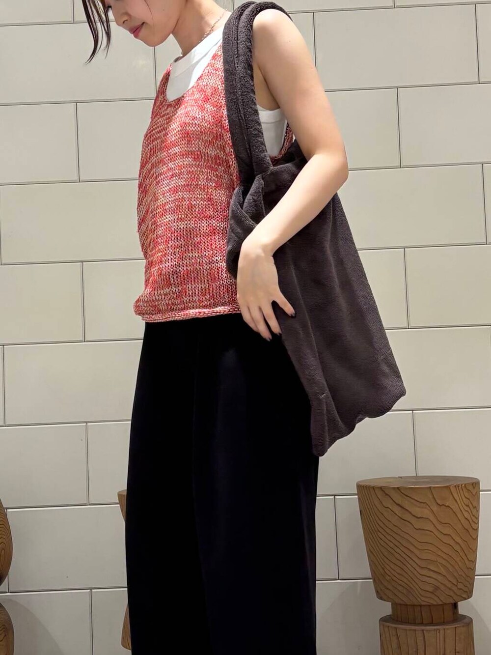 ブラック系のその他パンツ、レッド系のニット/セーター、ホワイト系のタンクトップを着用したレディースの夏コーディネートの4枚目の写真