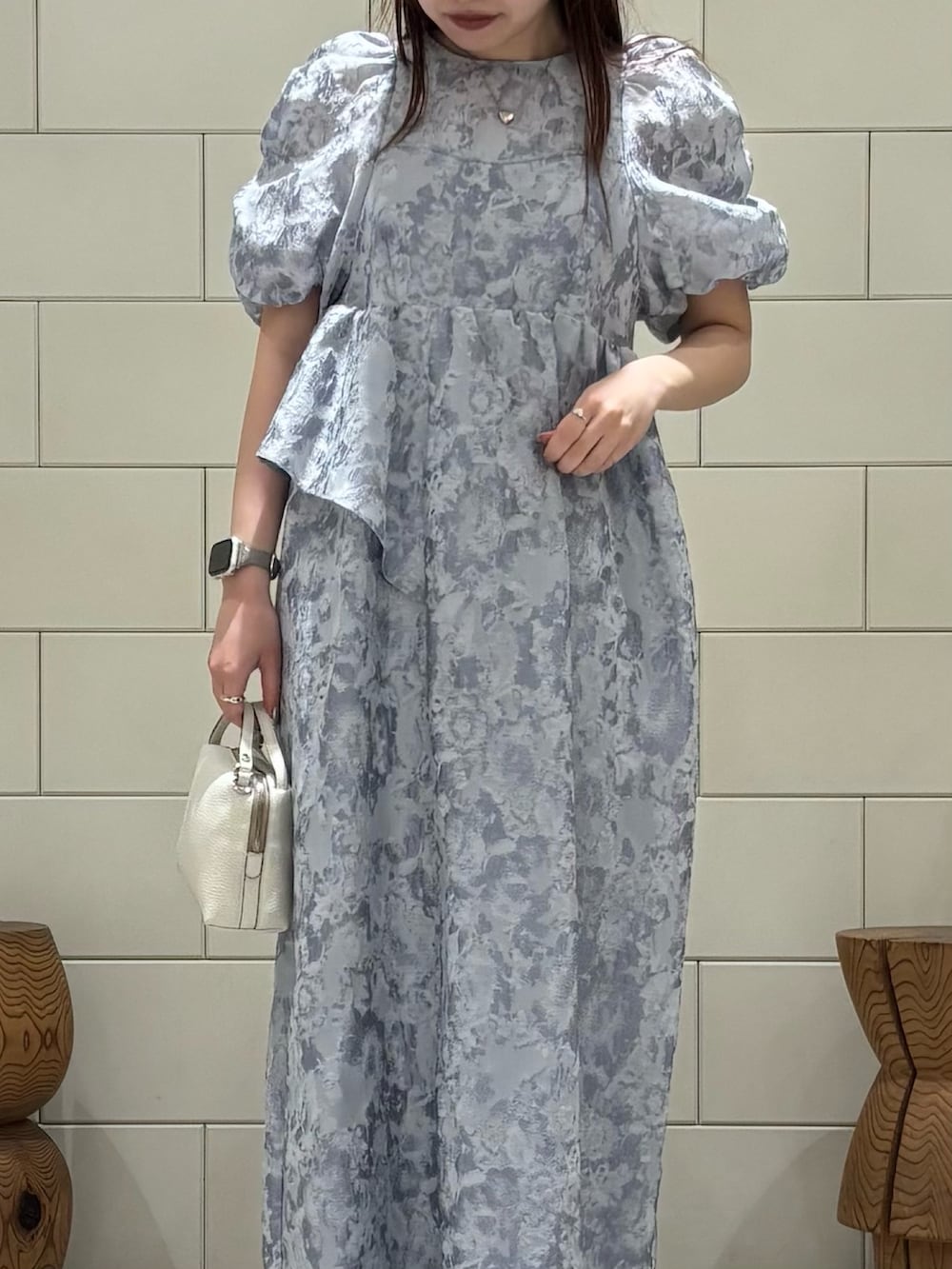 グレー系のドレス、ホワイト系のショルダーバッグを着用したレディースの春コーディネートの4枚目の写真