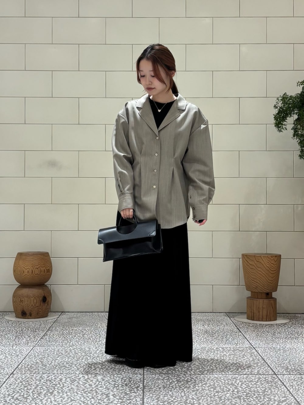 ブラック系のワンピース、ベージュ系のシャツ/ブラウス、ブラック系のハンドバッグを着用したレディースの冬コーディネートの2枚目の写真