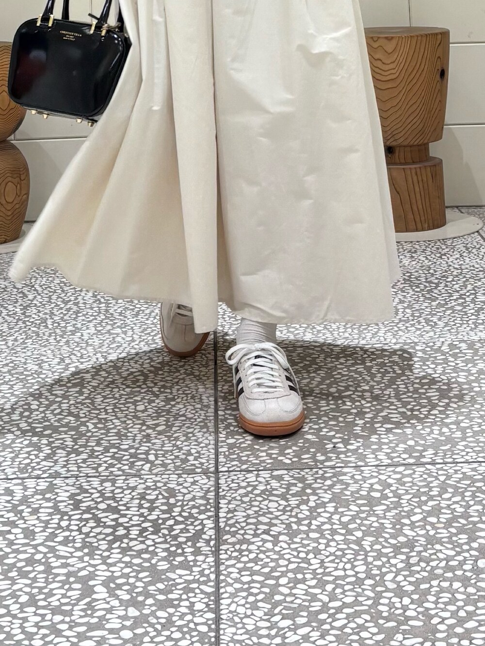 ホワイト系のTシャツ/カットソー、ブラウン系のベスト、ホワイト系のスカートを着用したレディースの秋コーディネートの5枚目の写真