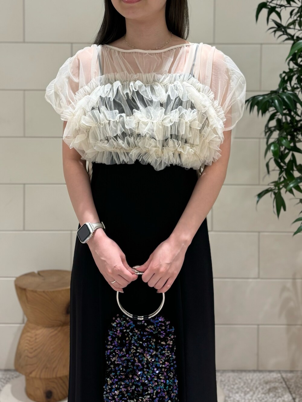 ブラック系のワンピース、パープル系のハンドバッグ、シルバー系のネックレスを着用したレディースの秋コーディネートの4枚目の写真