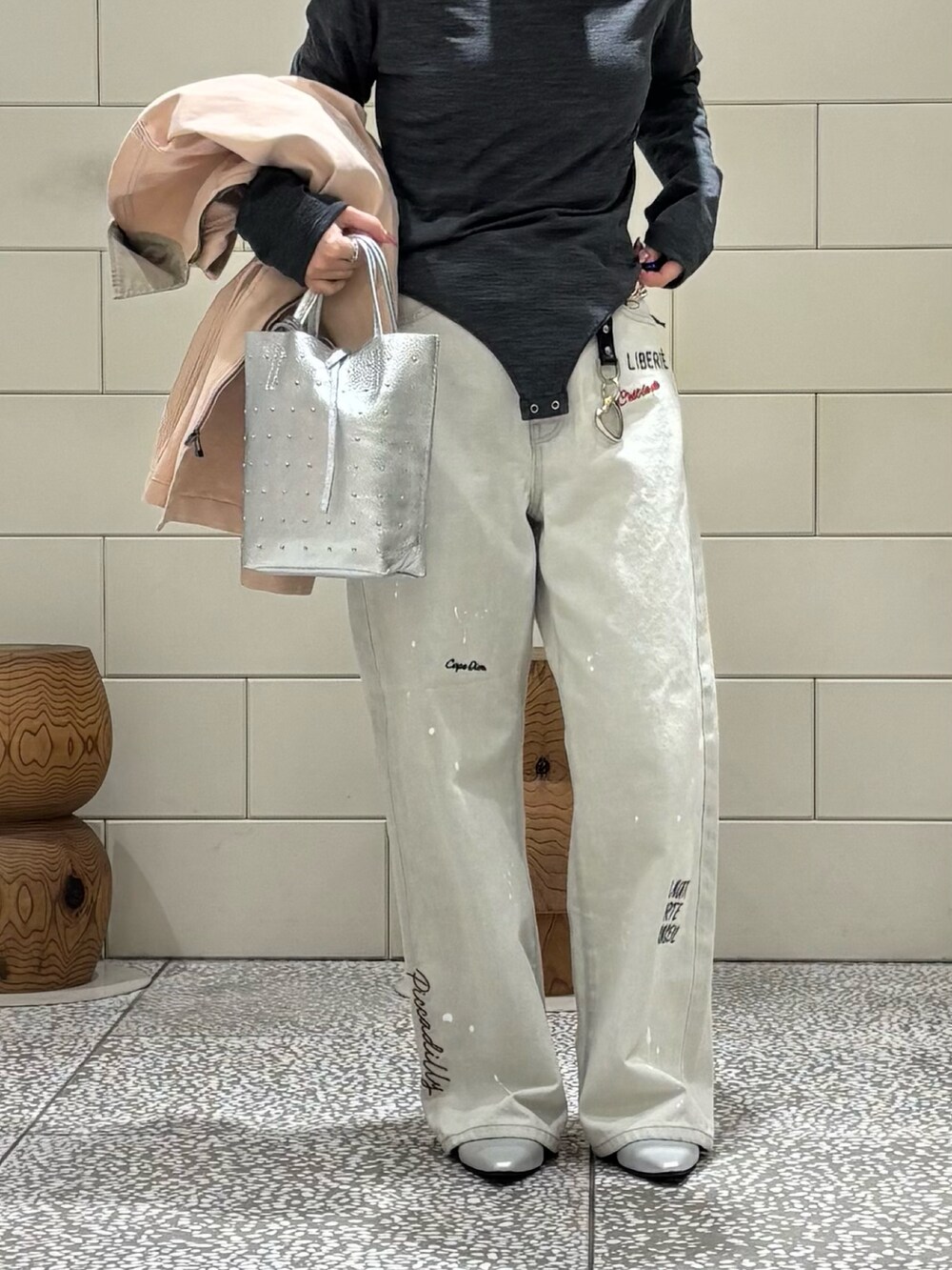 ピンク系のカバーオール、シルバー系のトートバッグ、グレー系のデニムパンツを着用したレディースの冬コーディネートの4枚目の写真